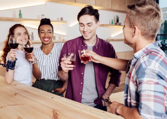 Młodzi ludzie pijący alkohol podczas spotkania towarzyskiego 